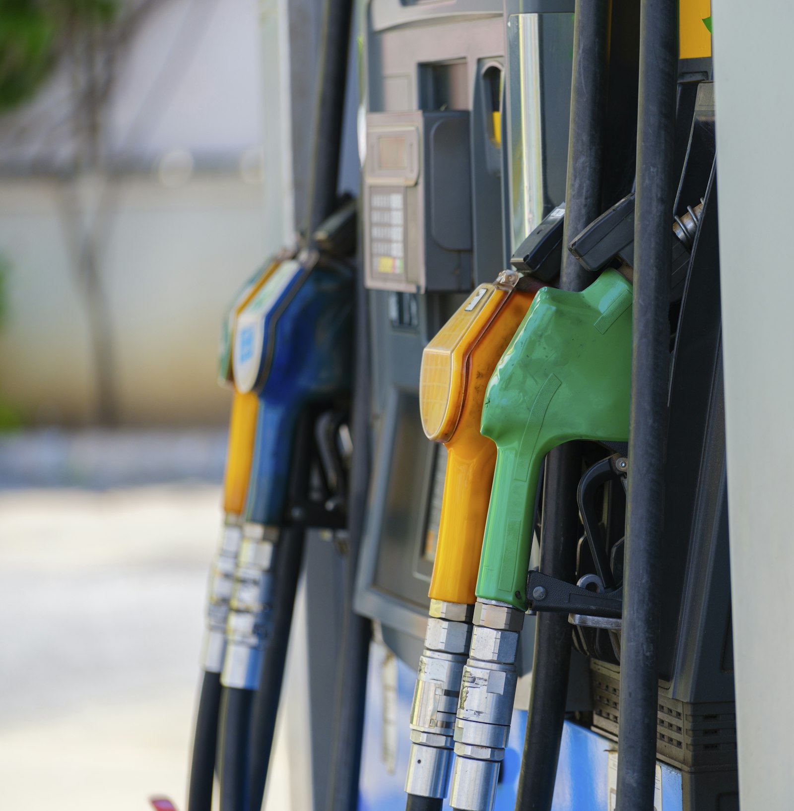 Fila de surtidores de combustible con sus mangueras y boquillas