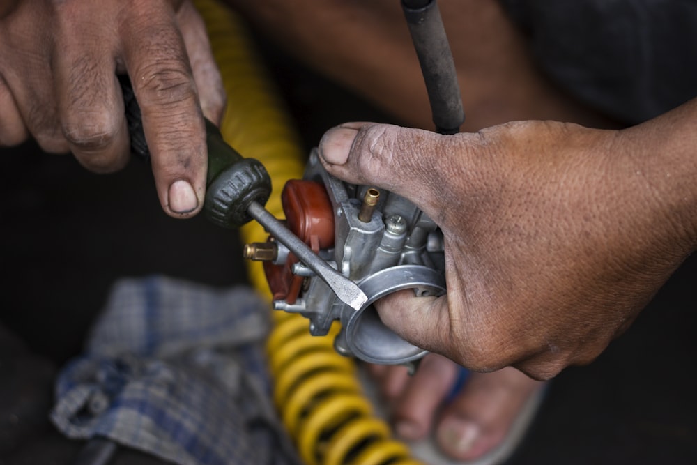Técnico reparando un componente mecánico con herramientas de mano